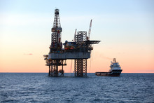 Offshore Oil Rig And Supply Vessel At Sunset