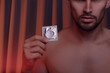 Cropped shot of young man holding condom