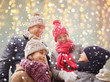 © Syda Productions - happy family over christmas lights and snow