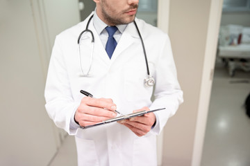 Wall Mural - close up of doctor with clipboard at hospital