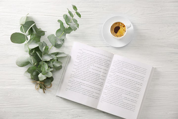 Poster - Green eucalyptus branches with cup of coffee on table