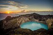 Sunrise on top of the Kelimutu volcano at Flores, Indonesia. On the front you can see the beautiful aqua colored crater lake of the volcano