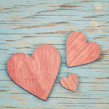 Three Pink Wooden Hearts Placed Nicely On A Blue Vintage Wood Ba