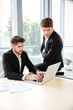 © Drobot Dean - Two businessmen using laptop in office together