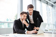 © Drobot Dean - Two cheerful young businessmen using laptop on business meeting together
