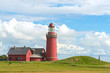 The red Lighthouse Bovbjerg Fyr with green grass and blue sky, J