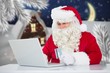 © vectorfusionart - Santa claus doing online shopping with credit card on laptop