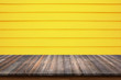 © ParinPIX - Wood table on yellow wood wall for background.