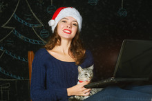 Girl With A Cat And A Laptop On A Dark Background. Merry Christmas