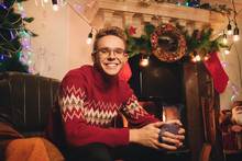 Smiling Guy On The Background Of Christmas Tree And Chimney