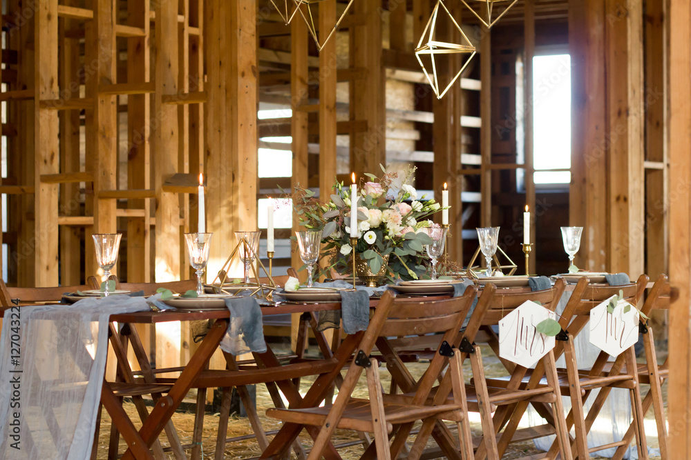Decoration wedding table before a banquet in a wooden barn. - obrazy, fototapety, plakaty 