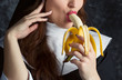 attractive nun holding a banana and bites him on a dark background