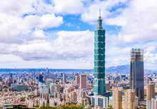 Aerial Panorama Over Downtown Taipei, Capital City Of Taiwan With View Of Prominent Taipei 101 Tower Amid Skyscrapers In Xinyi Financial District & Overcrowded Buildings In City Center Under Sunny Sky