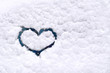 Snow background. Texture of wet snow with drawing a heart symbol  in the winter window glass of the car outdoors close-up. Happy romantic image.