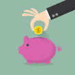 © gustbuster - hand putting coin into the piggy money box