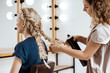 © Cookie Studio - Female hairdresser making hairstyle to blonde girl in beauty salon.