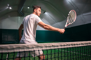 Pleasant professional sportsman playing tennis