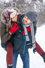 Wall Mural - Couple having fun in snow covered park