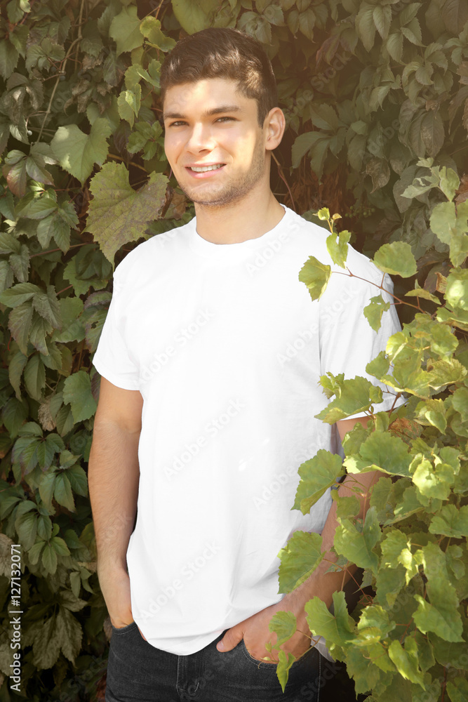 Handsome man on green leaves background