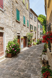 Fototapeta Uliczki - Narrow old street with flowers in Italy