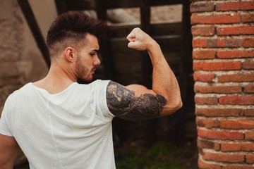 Sticker - Strong guy with a tattoo on his arm outside