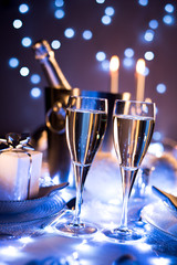 Wall Mural - dim light white silver and blue romantic new year eve or christmas table in a luxury restaurant with champagne