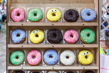 Assorted Tasty Colorful Donuts On Wooden Showcase, Close Up View