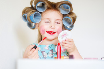 Adorable funny little girl making makeup with mother cosmetics