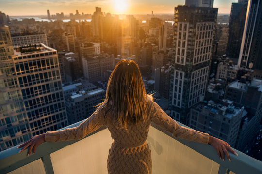 rich woman enjoy the sunset standing on the balcony at luxury apartments in new york city. luxury li