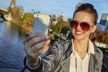 trendy woman  taking selfie with phone in Paris