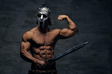 Wall Mural - A man in a silver gladiator helmet holds an iron sword.