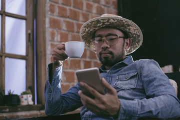 young men drinking coffee and reading messages from a mobile pho