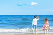 Boy and girl at the beach with a kite. Freedom concept. Carefree