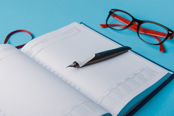 Wall Mural - notebook on blue paper. open diary and pen to record