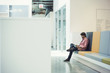 © Westend61 - Young businessman sitting in lobby using digital tablet