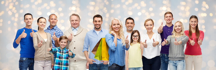 Canvas Print - happy people with shopping bags showing thumbs up