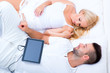 © Spectral-Design - Beautiful young couple using a Tablet PC in Bed