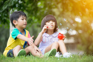 Children in the park blowing soap bubbles