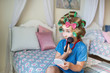 © kristinakibler - Pretty little girl with a curlers makeup on a bed