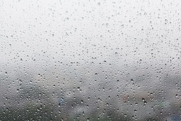 Rain drops on window glasses surface with cloudy background . Na