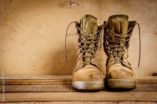 Fotografía old brown military boots on a wooden table