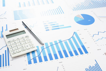 Accounting data, charts, calculator and pen. Many charts and graphs. Reflection background.
