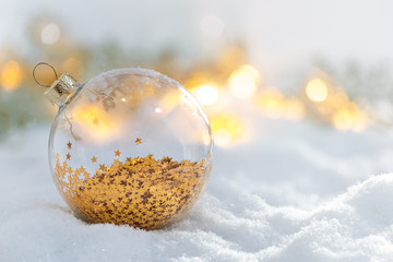 Christmas decoration glass ball at snowy sunrise