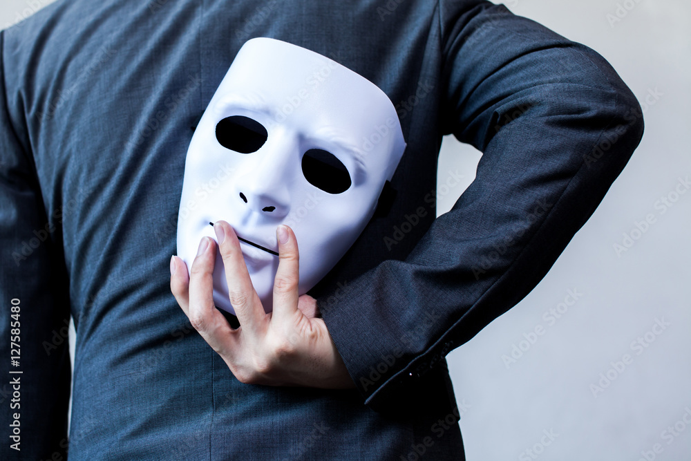 Business man carrying white mask to his body indicating Business fraud and faking business partnership