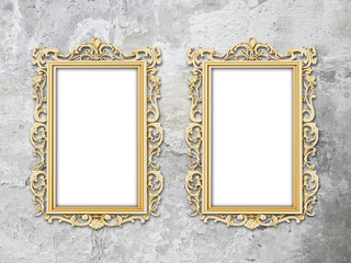 Two blank golden Baroque picture frames on weathered wall background