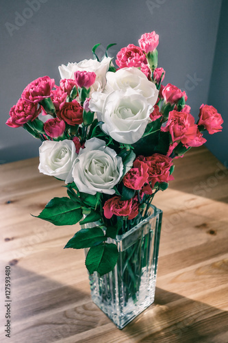 Fotografija Bouquet of white roses and cloves in glass vase