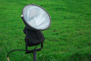 A ground spotlight in the green yard