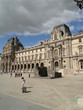 Tourists gather in the courtyard of the Louvre Museum