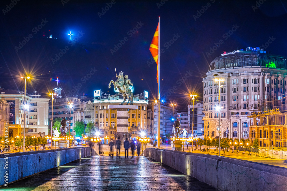 Night view of the ancient stone bridge in the macedonian capital skopje leading to the macedonia square dominated by statue of alexander the great. - obrazy, fototapety, plakaty 