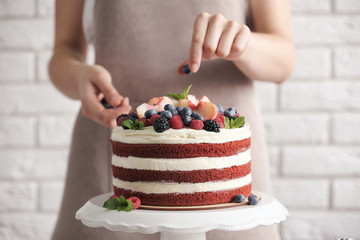 Woman decorating delicious cake